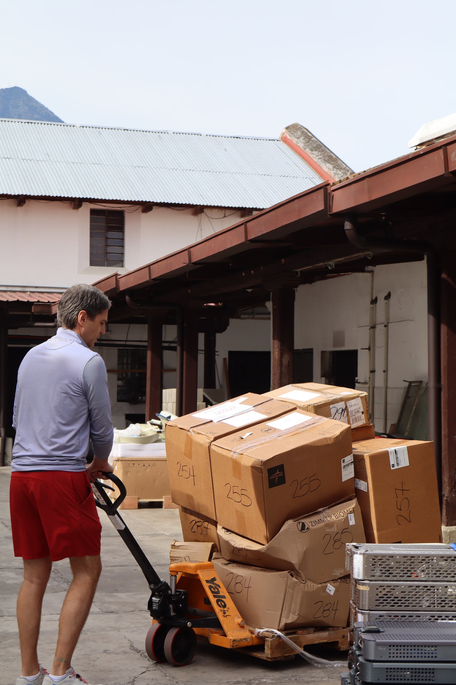 Team members unpack boxes of supplies in the hospital courtyard.